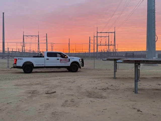 Allied Fence and Security truck parked inside an electrical substation at sunset