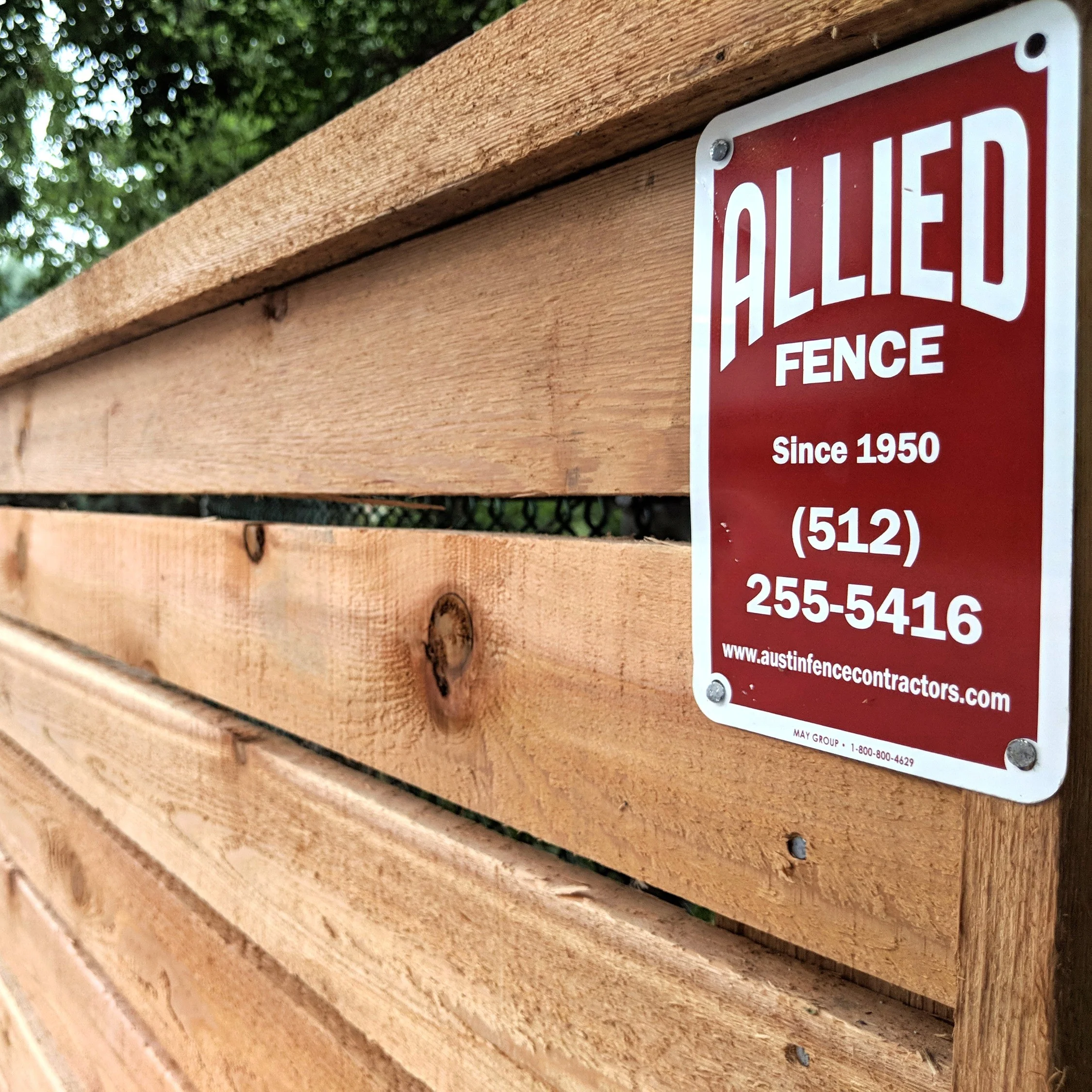 Allied Fence yard sign mounted on a newly built horizontal cedar privacy fence