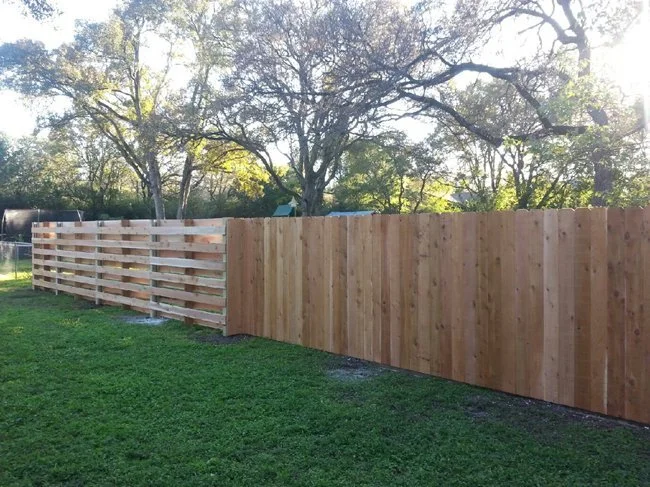 Cedar privacy fence with a horizontal slat upper section enclosing a residential backyard
