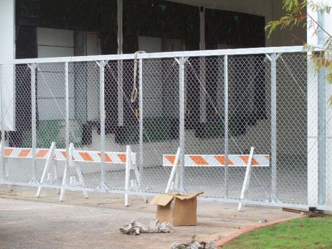 White chain link panels and traffic barricades outside a commercial building
