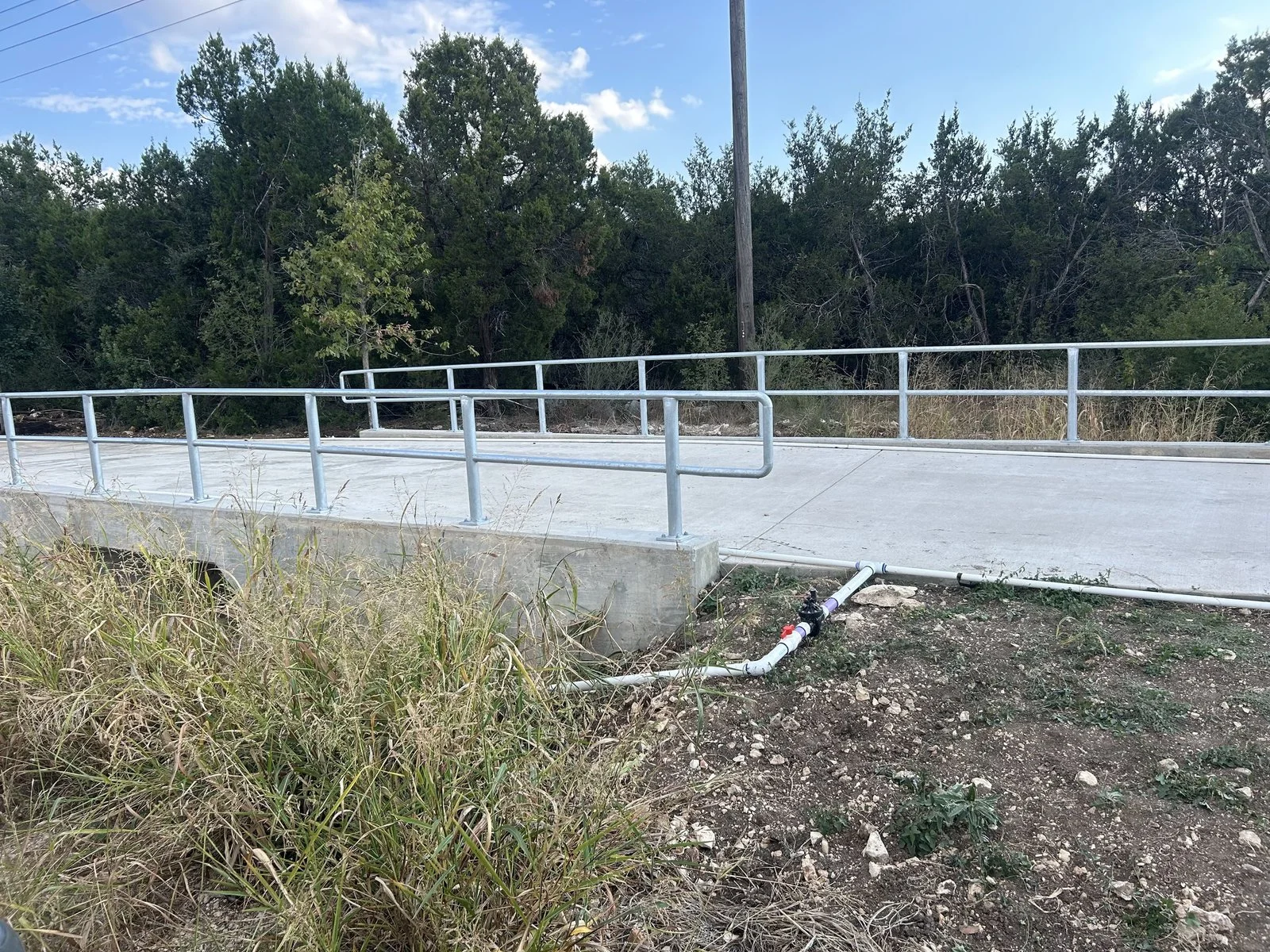 Concrete access ramp finished with a welded steel handrail