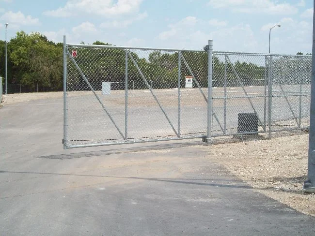 Galvanized chain link cantilever slide gate across a commercial drive