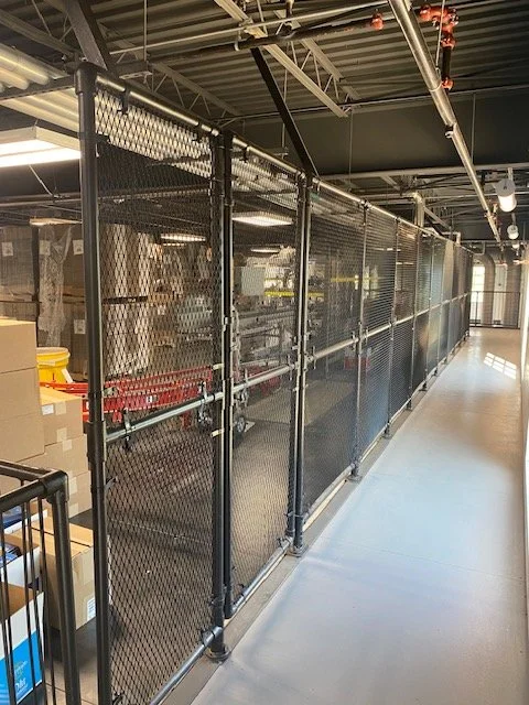 Interior chain link security caging lining a warehouse corridor